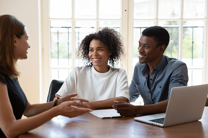 smiling black couple at table with financial planner
